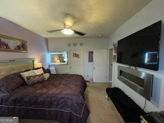 bedroom with carpet, a fireplace, and ceiling fan