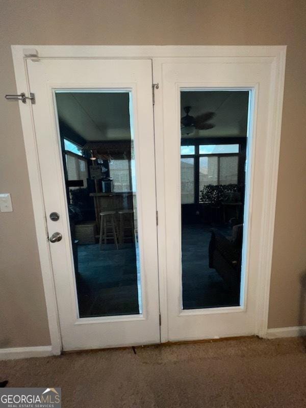 doorway to outside featuring carpet and baseboards