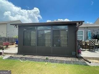 rear view of house with a sunroom and fence