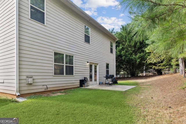 rear view of house with french doors, a patio area, and a lawn