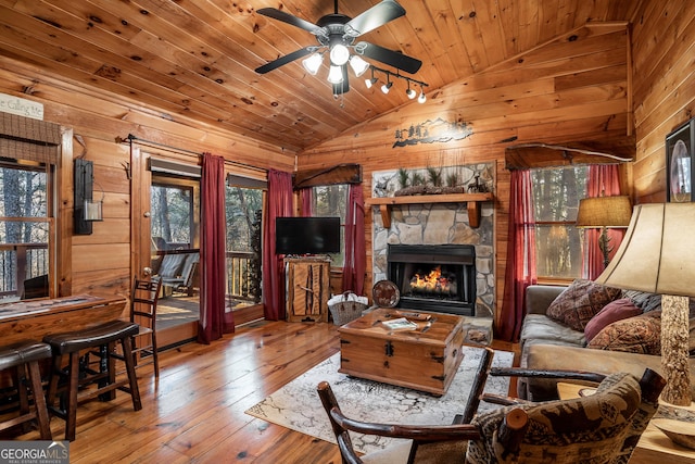 living area with lofted ceiling, wood-type flooring, wood walls, and wooden ceiling