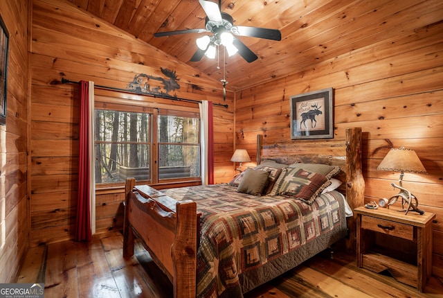 bedroom featuring wooden walls, wood ceiling, hardwood / wood-style floors, and vaulted ceiling