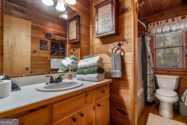 full bath with wooden walls, wooden ceiling, toilet, and vanity