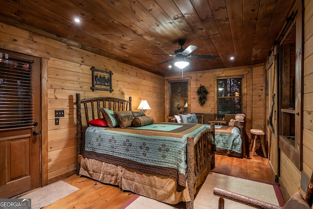 bedroom with light wood-style flooring, wooden ceiling, and wood walls