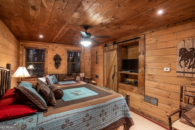 bedroom with wooden walls, carpet, visible vents, a barn door, and wooden ceiling