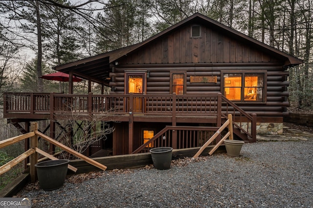 rear view of property featuring log siding, stairs, and a deck