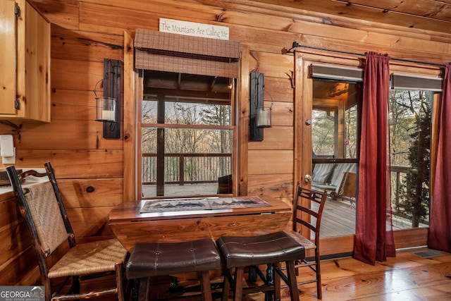 dining space featuring wooden walls and wood finished floors