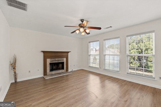 unfurnished living room with visible vents, baseboards, and wood finished floors