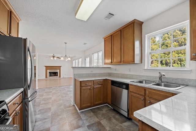 kitchen with visible vents, appliances with stainless steel finishes, brown cabinets, and a sink