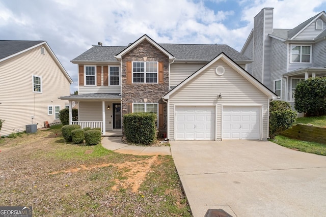 traditional-style home with a porch, central air condition unit, a garage, stone siding, and driveway