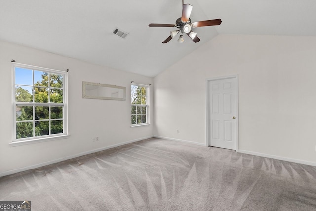 carpeted empty room with a ceiling fan, lofted ceiling, visible vents, and baseboards