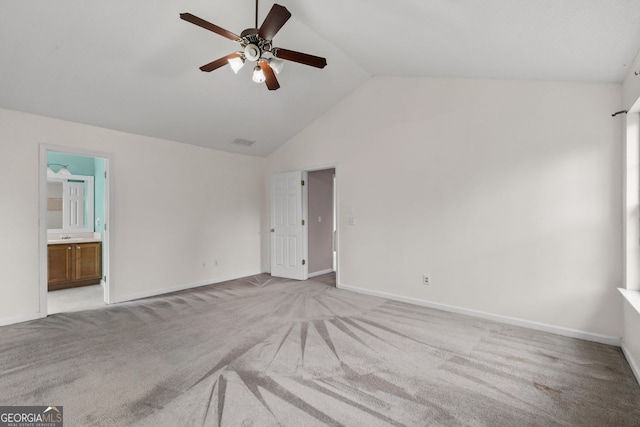 unfurnished bedroom featuring ensuite bathroom, visible vents, baseboards, vaulted ceiling, and carpet