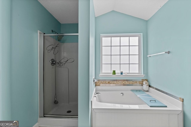 bathroom featuring a stall shower, a garden tub, and vaulted ceiling