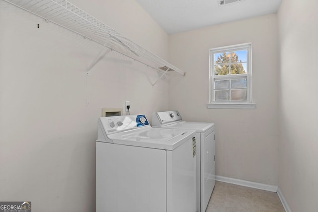 washroom with laundry area, washing machine and dryer, visible vents, and baseboards