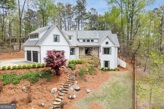 view of front facade with a garage, stairway, and concrete driveway