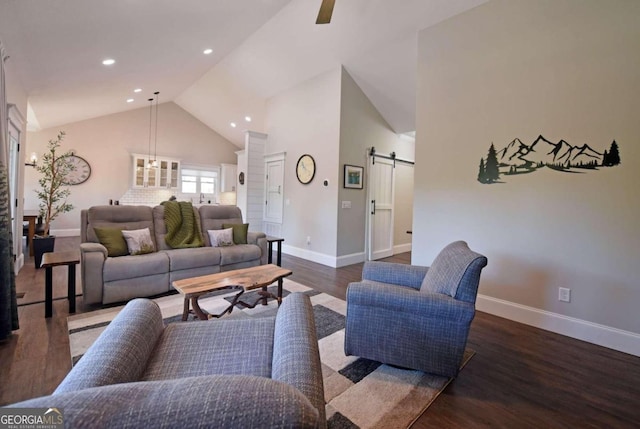 living area featuring high vaulted ceiling, a barn door, recessed lighting, wood finished floors, and baseboards