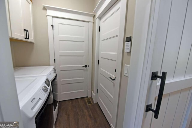 laundry room featuring cabinet space, dark wood-style flooring, and washer and dryer