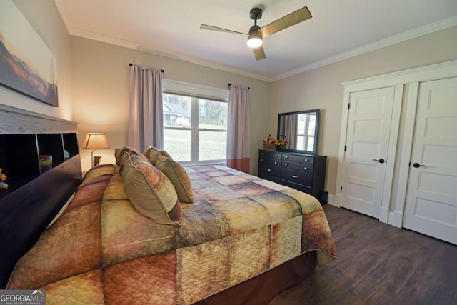 bedroom featuring dark wood-type flooring, ornamental molding, and a ceiling fan