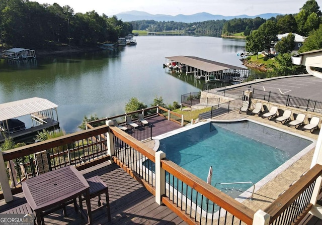 view of pool featuring a boat dock, a fenced in pool, and a water and mountain view