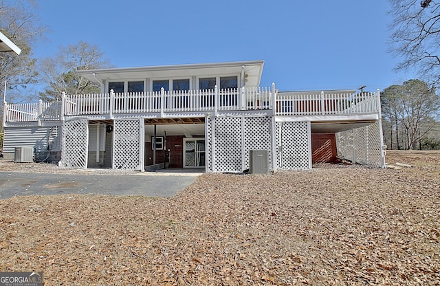 rear view of property with stairs, a deck, cooling unit, and brick siding