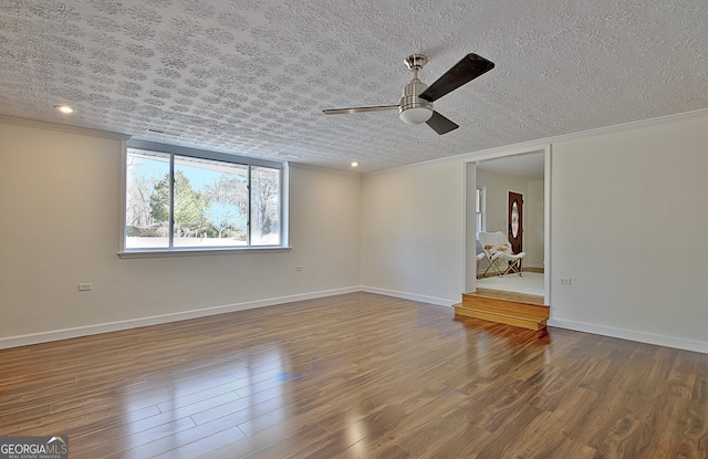 unfurnished living room with crown molding, a textured ceiling, baseboards, and wood finished floors