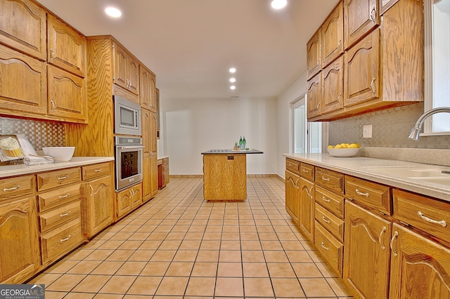 kitchen with decorative backsplash, light tile patterned flooring, stainless steel appliances, a sink, and recessed lighting