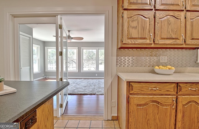 kitchen with light tile patterned floors, ceiling fan, and tasteful backsplash