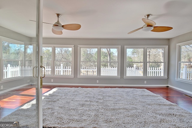 unfurnished sunroom with visible vents and a ceiling fan