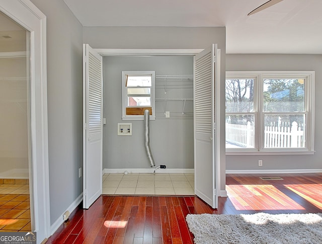 washroom with laundry area, wood-type flooring, washer hookup, and a wealth of natural light