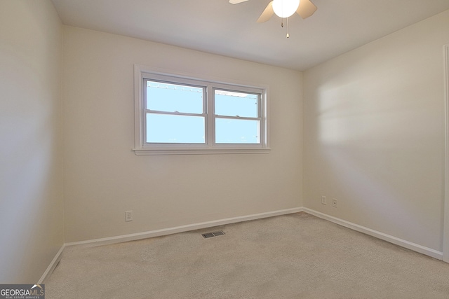 carpeted empty room with visible vents, ceiling fan, and baseboards