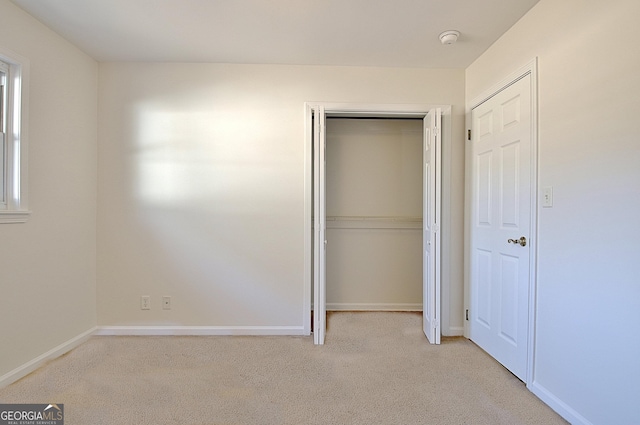 unfurnished bedroom featuring carpet floors, a closet, and baseboards