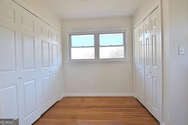 interior space with wood finished floors and baseboards