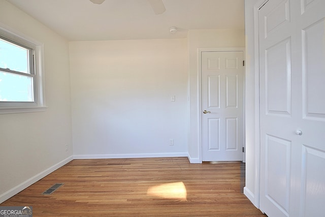 spare room with visible vents, ceiling fan, light wood-style flooring, and baseboards