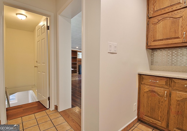 corridor with light tile patterned floors and baseboards