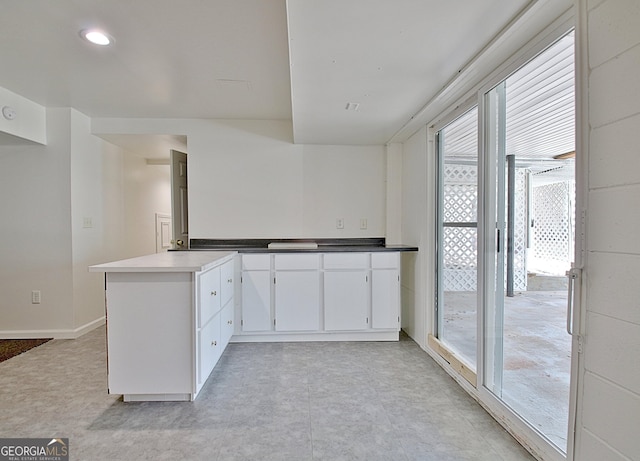 kitchen with a peninsula, white cabinetry, and recessed lighting