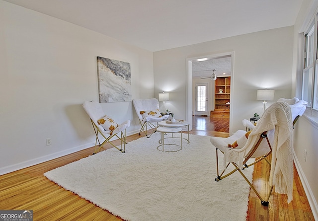 living area featuring baseboards and wood finished floors