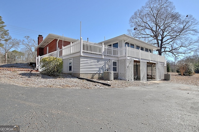 exterior space with a chimney and central AC unit