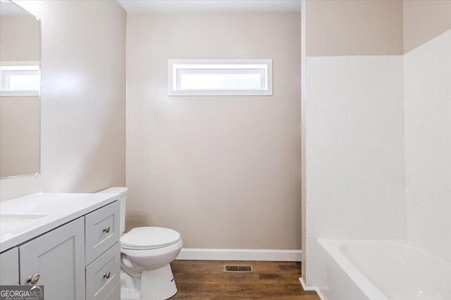 full bathroom with visible vents, baseboards, toilet, wood finished floors, and vanity