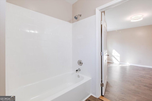 bathroom with bathtub / shower combination, baseboards, and wood finished floors