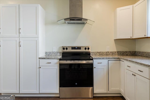 kitchen with light stone countertops, white cabinets, wall chimney exhaust hood, and stainless steel electric stove