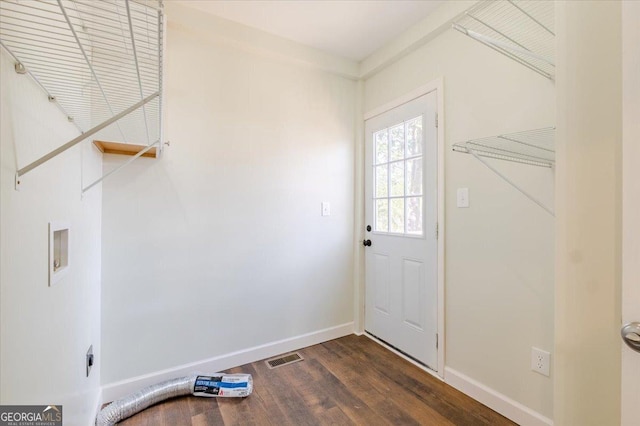 doorway to outside with dark wood-style floors, visible vents, and baseboards