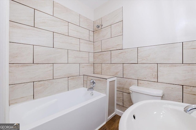 bathroom featuring a washtub and tile walls