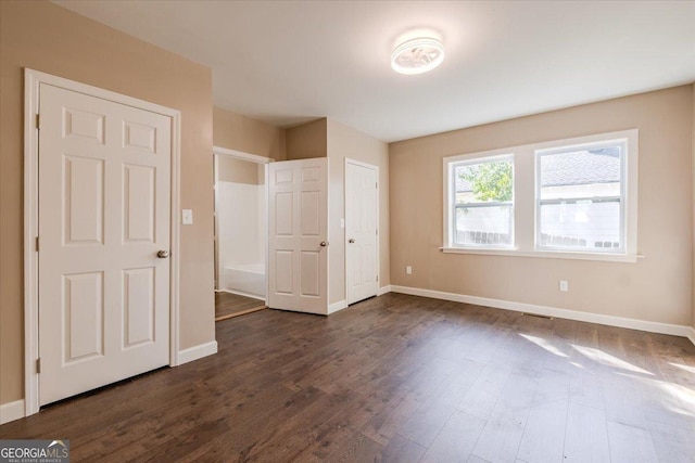 unfurnished bedroom featuring dark wood finished floors and baseboards