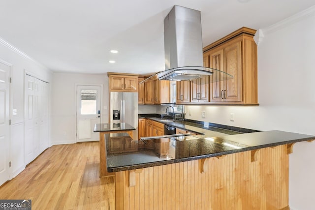 kitchen featuring island exhaust hood, light wood-style floors, ornamental molding, stainless steel fridge, and a peninsula