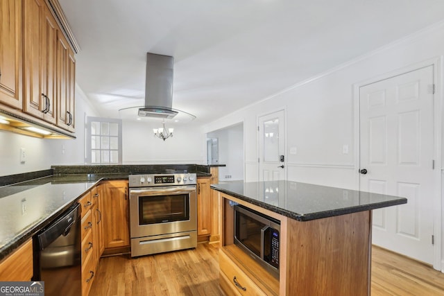 kitchen featuring light wood finished floors, island range hood, appliances with stainless steel finishes, a peninsula, and crown molding