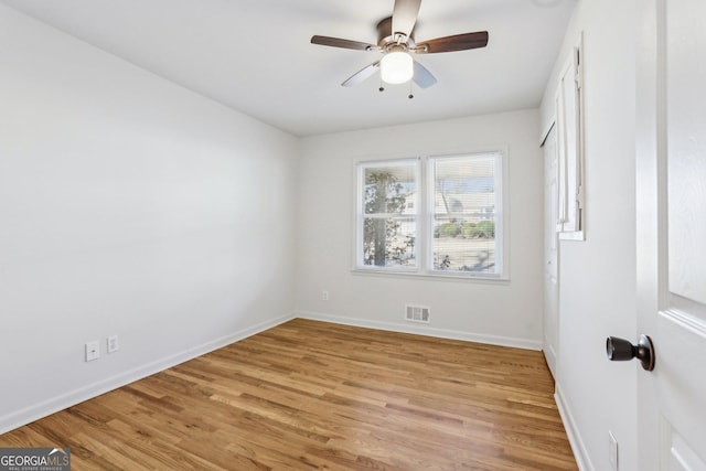 interior space with light wood-style flooring, a ceiling fan, visible vents, and baseboards