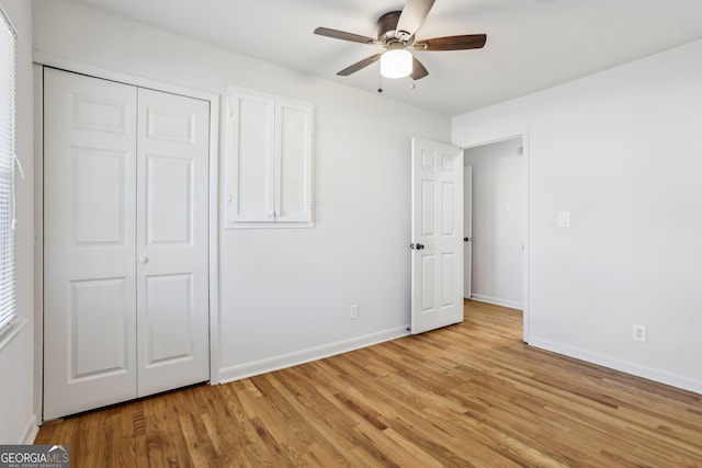 unfurnished bedroom with a ceiling fan, a closet, baseboards, and light wood finished floors