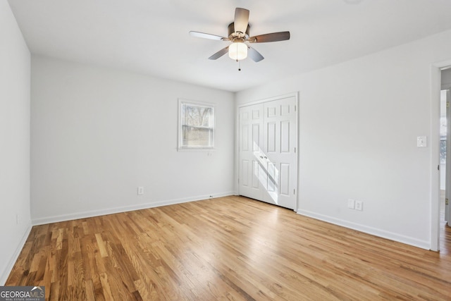 unfurnished bedroom featuring ceiling fan, light wood finished floors, a closet, and baseboards