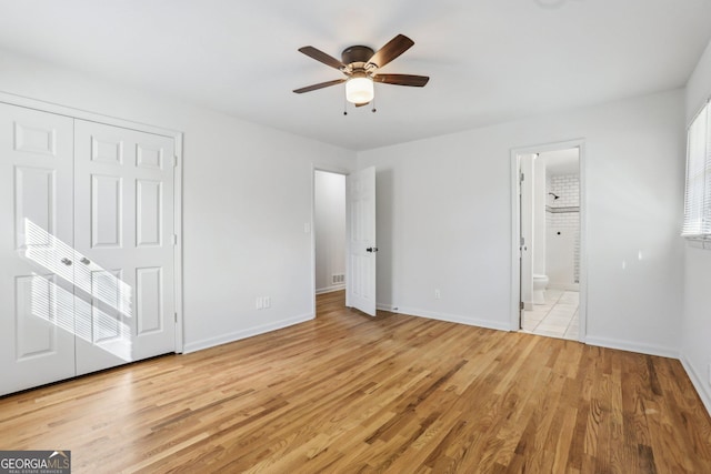 unfurnished bedroom featuring light wood-style floors, a closet, connected bathroom, and baseboards