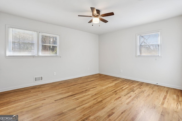 empty room with visible vents, ceiling fan, light wood-style flooring, and baseboards